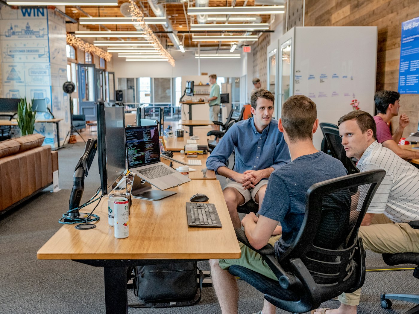 People collaborating around a table with laptops